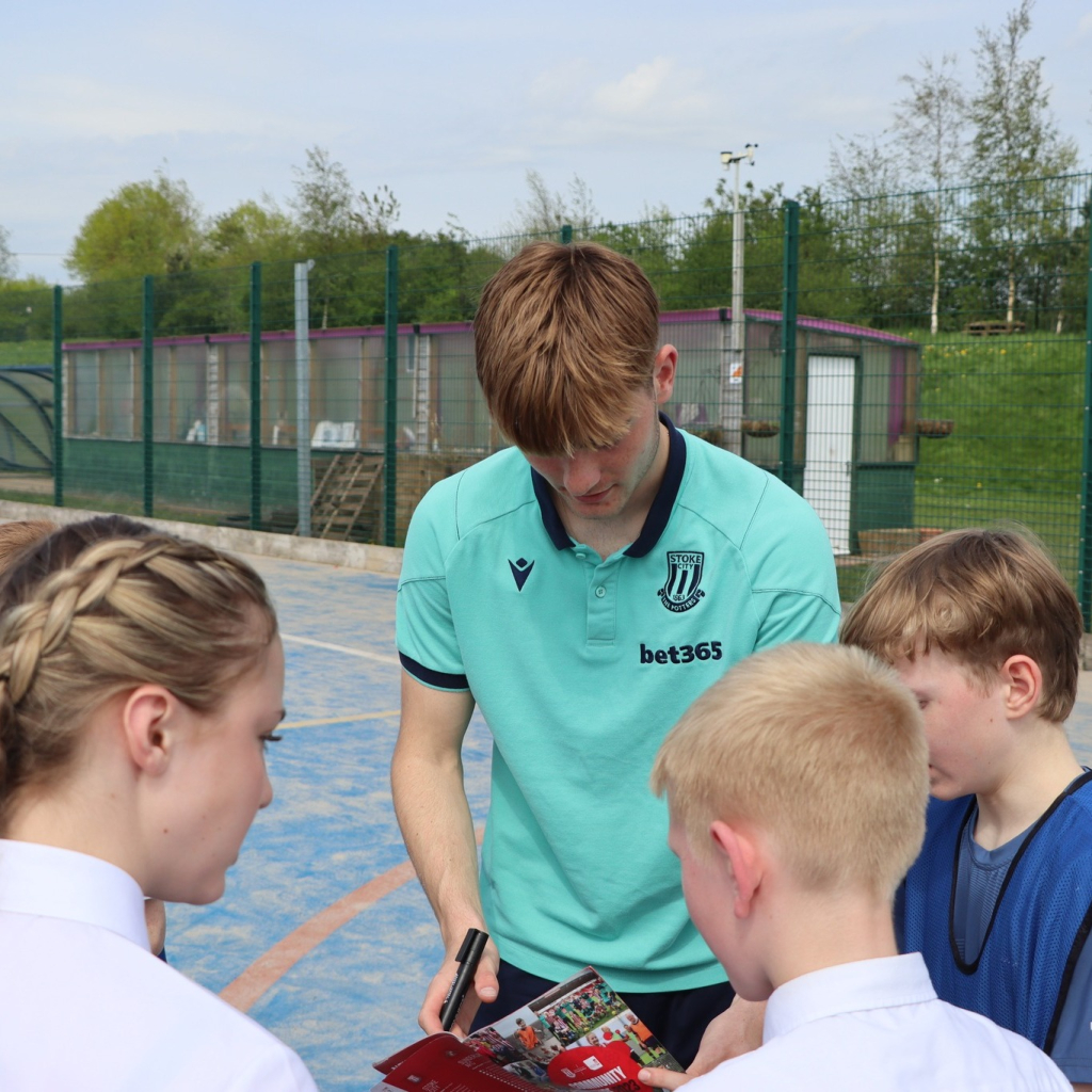 Stoke city football players with students