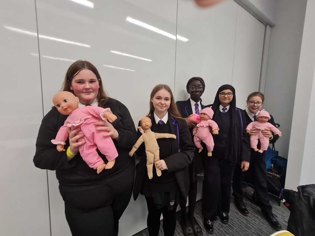 y10 social care students holiding baby dolls